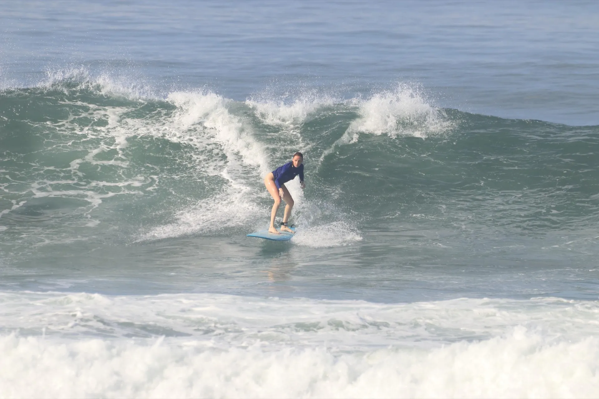 An intermediate surfer riding a clean wave during private coaching in Canggu